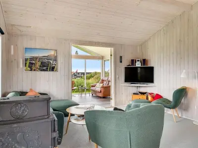 a living room with green chairs and a tv at Holiday Home Titta - 150m to the fjord by Interhome in Vinderup