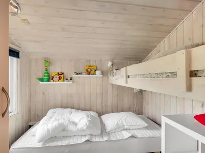 a small bedroom with a bunk bed and shelves at Holiday Home Titta - 150m to the fjord by Interhome in Vinderup