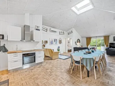 a kitchen and living room with a table and chairs at Holiday Home Veijo - 400m to the fjord by Interhome in Spottrup