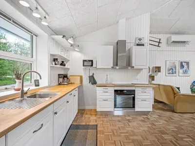 a kitchen with white cabinets and a sink at Holiday Home Veijo - 400m to the fjord by Interhome in Spottrup