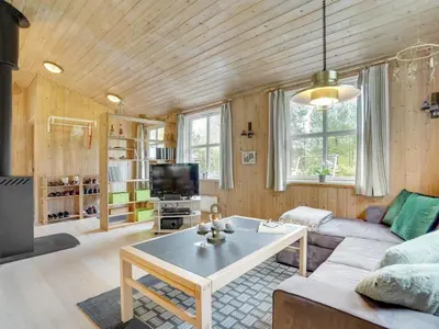 a living room with a couch and a table at Holiday Home Blome - 150m to the fjord by Interhome in Højslev