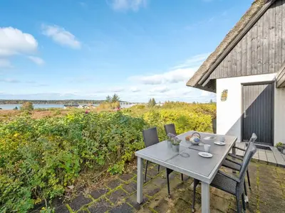 a table and chairs on the patio of a house at Holiday Home Tordis - 250m to the fjord by Interhome in Roslev