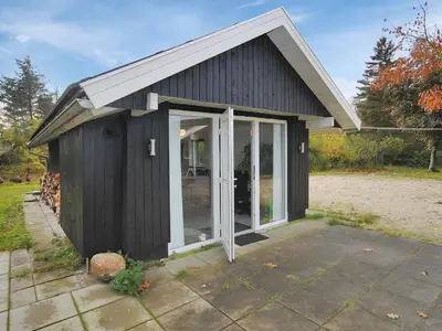 a small black shed with a large glass door at Holiday Home Elis - 90m to the fjord by Interhome in Roslev