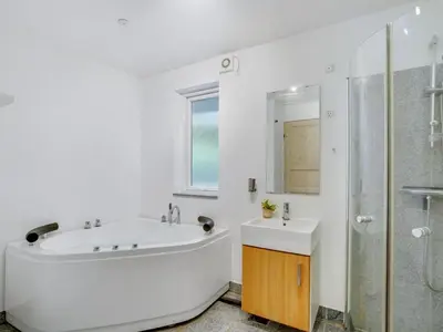 a white bathroom with a sink and a shower at Holiday Home Elis - 90m to the fjord by Interhome in Roslev
