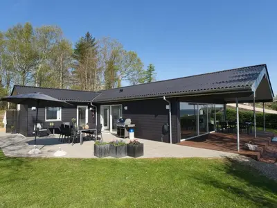 a house with a patio and an umbrella at Holiday Home Elissa - 50m to the fjord by Interhome in Roslev