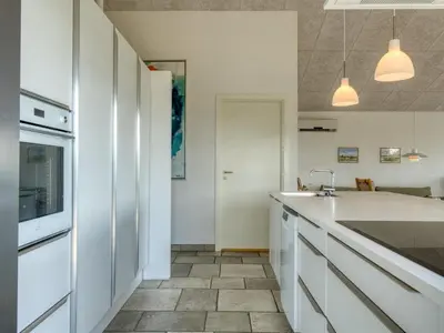 a kitchen with white cabinets and a sink at Holiday Home Elissa - 50m to the fjord by Interhome in Roslev