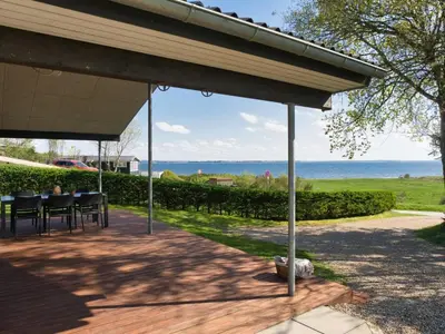 a patio with chairs and a view of the ocean at Holiday Home Elissa - 50m to the fjord by Interhome in Roslev