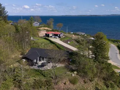an aerial view of a house on a hill next to the ocean at Holiday Home Elissa - 50m to the fjord by Interhome in Roslev