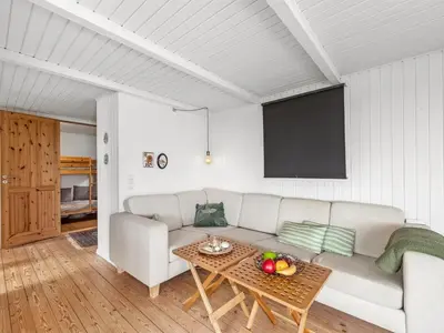 a living room with a couch and a table at Holiday Home Heera - 100m to the fjord by Interhome in Lihme
