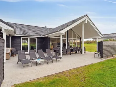 a patio with chairs and tables on it at Holiday Home Sibbe - 500m to the fjord by Interhome in Spottrup