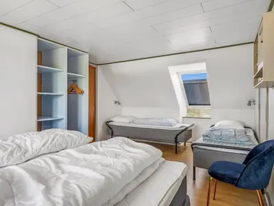 a room with two beds and a chair in it at Holiday Home Kara - 100m to the fjord by Interhome in Fur
