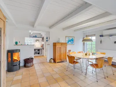 a living room with a table and a fireplace at Holiday Home Althea - 750m to the fjord by Interhome in Fur