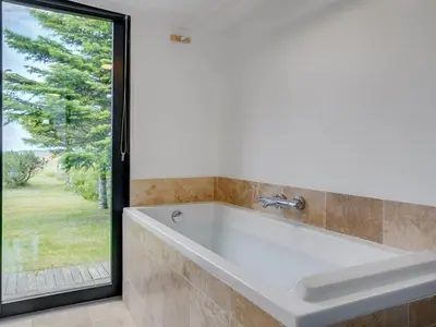 a bath tub in a bathroom with a window at Holiday Home Lok - 90m to the fjord by Interhome in Roslev