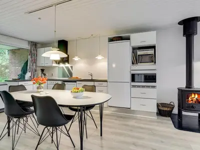 a kitchen with a table and chairs and a stove at Holiday Home Ephra - 250m to the fjord by Interhome in Roslev