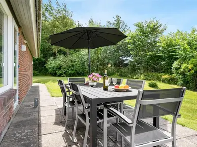 a table and chairs with an umbrella on a patio at Holiday Home Ephra - 250m to the fjord by Interhome in Roslev