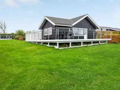 a large house with a green lawn in front of it at Holiday Home Clarita - 300m to the fjord by Interhome in Roslev