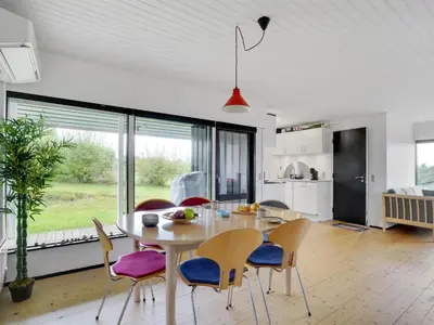 a kitchen and dining room with a table and chairs at Holiday Home Clarita - 300m to the fjord by Interhome in Roslev