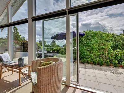a patio with a table and an umbrella at Holiday Home Regni - 300m to the fjord by Interhome in Nykøbing Mors