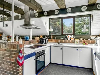 a kitchen with white cabinets and a brick wall at Holiday Home Paale - 200m to the fjord by Interhome in Fur
