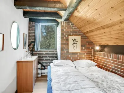a bedroom with a bed and a brick wall at Holiday Home Paale - 200m to the fjord by Interhome in Fur