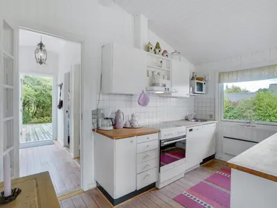 a white kitchen with white cabinets and a window at Holiday Home Suoma - 400m to the fjord by Interhome in Roslev