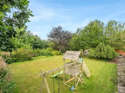 a wooden playground in a yard with trees at Holiday Home Auguste - 1-5km to the fjord by Interhome in Fur