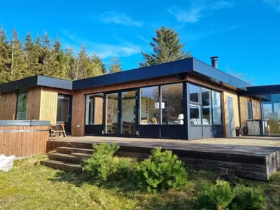 a house with a large deck and large windows at Holiday Home Lefke - 400m to the fjord by Interhome in Roslev
