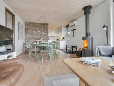 a living room with a table and a fireplace at Holiday Home Lefke - 400m to the fjord by Interhome in Roslev