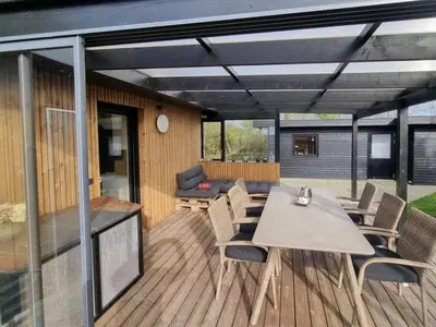a patio with a table and chairs on a deck at Holiday Home Lefke - 400m to the fjord by Interhome in Roslev