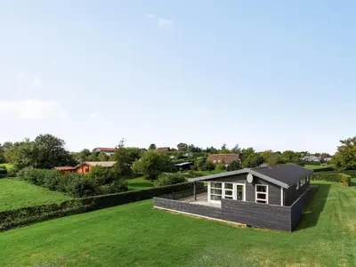 a small house on a large grassy field at Holiday Home Sylvelin - 400m to the fjord by Interhome in Roslev