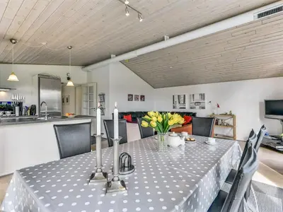 a dining room table with flowers and candles on it at Holiday Home Sylvelin - 400m to the fjord by Interhome in Roslev