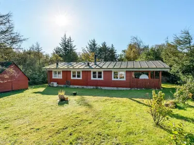a red house in a yard with a dog at Holiday Home Thrine - 100m to the fjord by Interhome in Fur