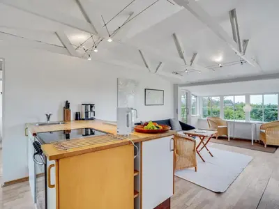 a kitchen with a counter and a living room at Holiday Home Gren - 90m to the fjord by Interhome in Roslev