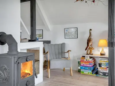 a living room with a fireplace and a chair at Holiday Home Brunhild - 300m to the fjord by Interhome in Fur