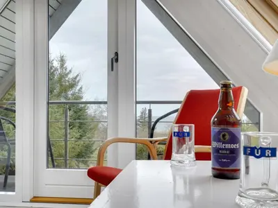 a bottle of beer sitting on a table in front of a window at Holiday Home Brunhild - 300m to the fjord by Interhome in Fur