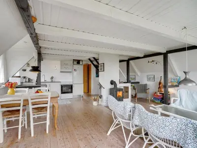 a kitchen and living room with a table and chairs at Holiday Home Brunhild - 300m to the fjord by Interhome in Fur