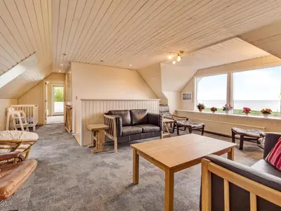 a living room with a couch and a table at Holiday Home Emmie - 50m to the fjord by Interhome in Skarum