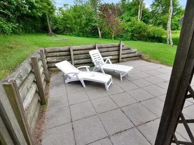 two white chairs are sitting on a patio at Holiday Home Pirkka - 50m to the fjord by Interhome in Løgstrup