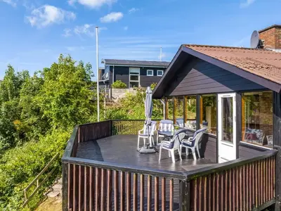 a deck with chairs and tables on a house at Holiday Home Imgert - 300m to the fjord by Interhome in Løgstrup