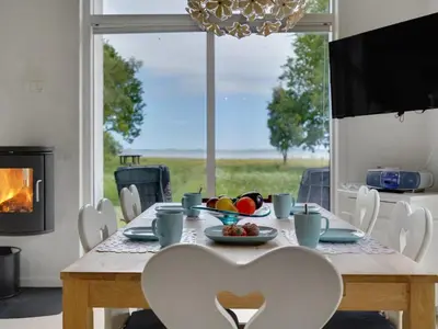 a dining room with a table with a bowl of fruit at Holiday Home Ødger - 150m to the fjord by Interhome in Åbybro