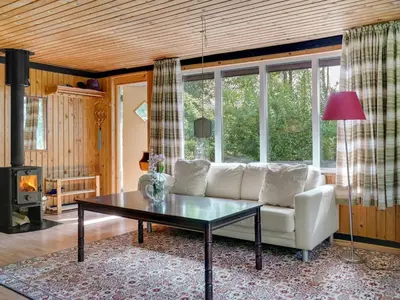 a living room with a white couch and a table at Holiday Home Lennert - 100m to the fjord by Interhome in Åbybro