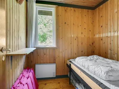 a bedroom with a bed in a wooden room at Holiday Home Lennert - 100m to the fjord by Interhome in Åbybro