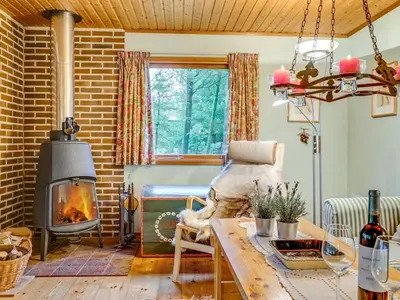 a living room with a fireplace and a table at Holiday Home Carina - 5km from the sea by Interhome in Brovst
