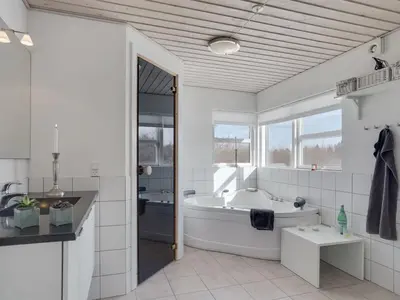 a white bathroom with a tub and a sink at Holiday Home Asel - 4km from the sea by Interhome in Brovst