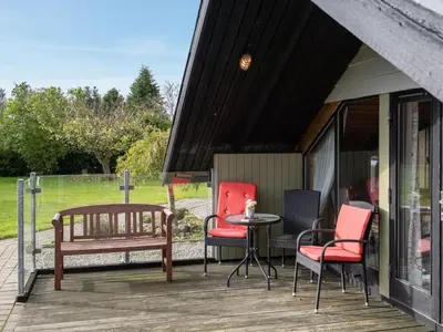 a porch with chairs and a table and a bench at Holiday Home Tenho - 4-4km from the sea by Interhome in Brovst