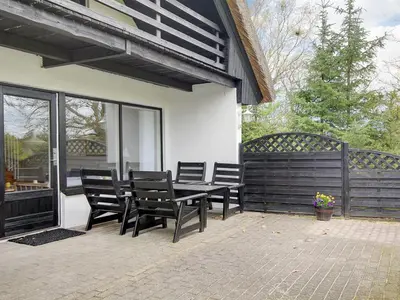 a patio with chairs and a table on a house at Holiday Home Rigitte - 1-5km from the sea by Interhome in Pandrup