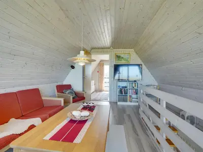 a living room with a red couch and a table at Holiday Home Viona - 350m from the sea by Interhome in Pandrup