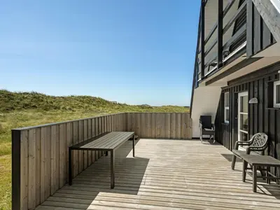 a wooden deck with two benches on the side of a building at Holiday Home Viona - 350m from the sea by Interhome in Pandrup