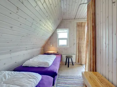 two beds in a small room with a window at Holiday Home Viona - 350m from the sea by Interhome in Pandrup