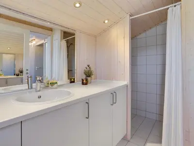 a white bathroom with a sink and a shower at Holiday Home Fanney - 100m from the sea by Interhome in Pandrup